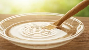 Sabonete Artesanal Não Hidrata? Você Vai Se Chocar Com a Verdade por Trás da Glicerina! 11 Sabonete artesanal não hidrata translúcido dourado com gotículas de água, em base de madeira rústica, transmitindo frescor e naturalidade